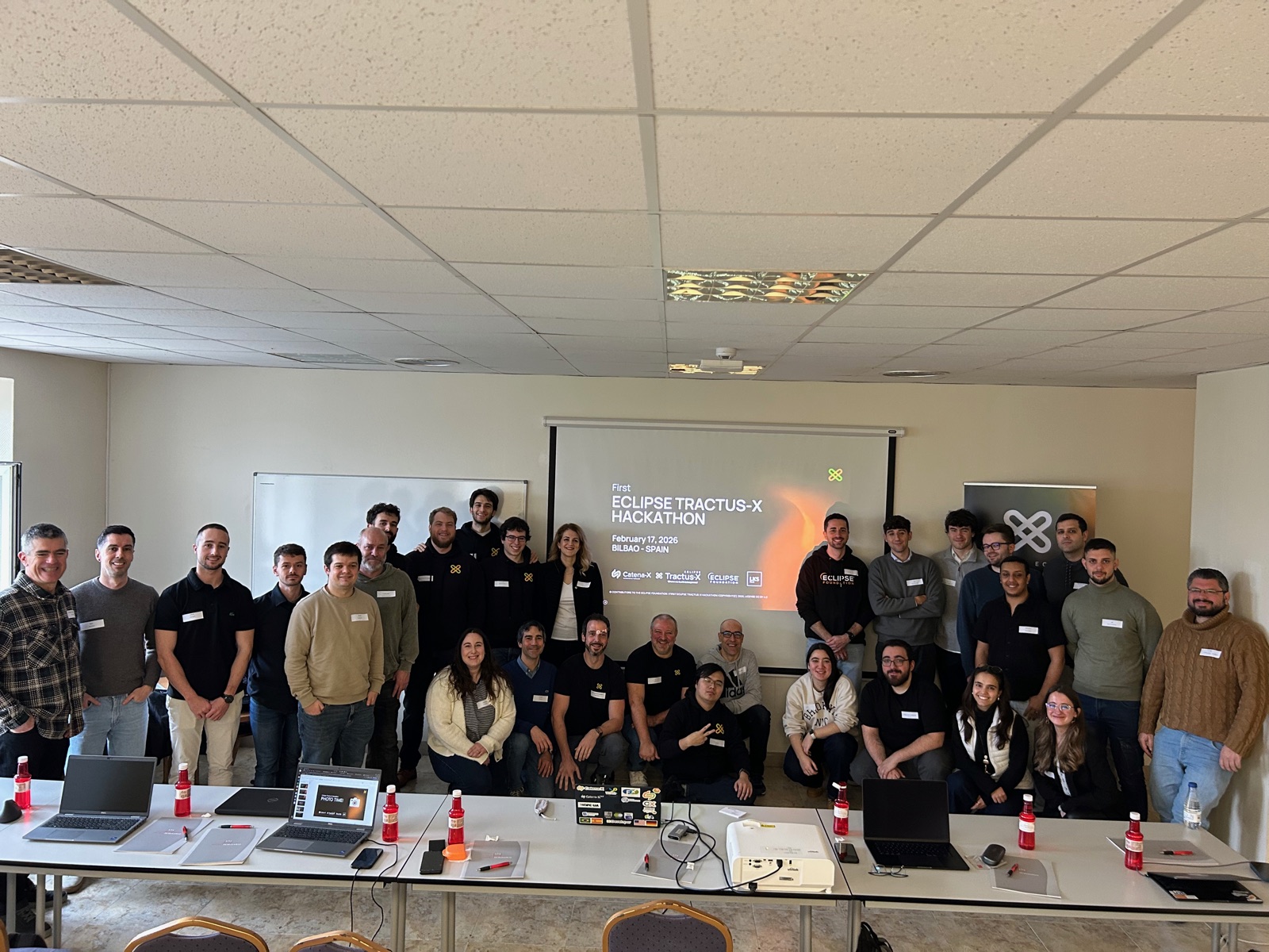 Group photo of all participants of the First Eclipse Tractus-X Hackathon in front of the event screen